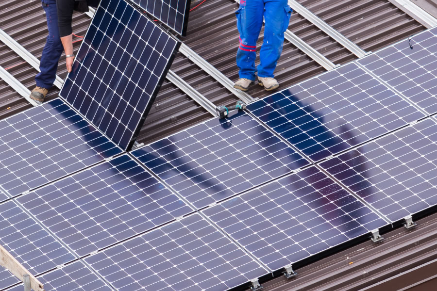 Instaladores montando paneles solares en una cubierta